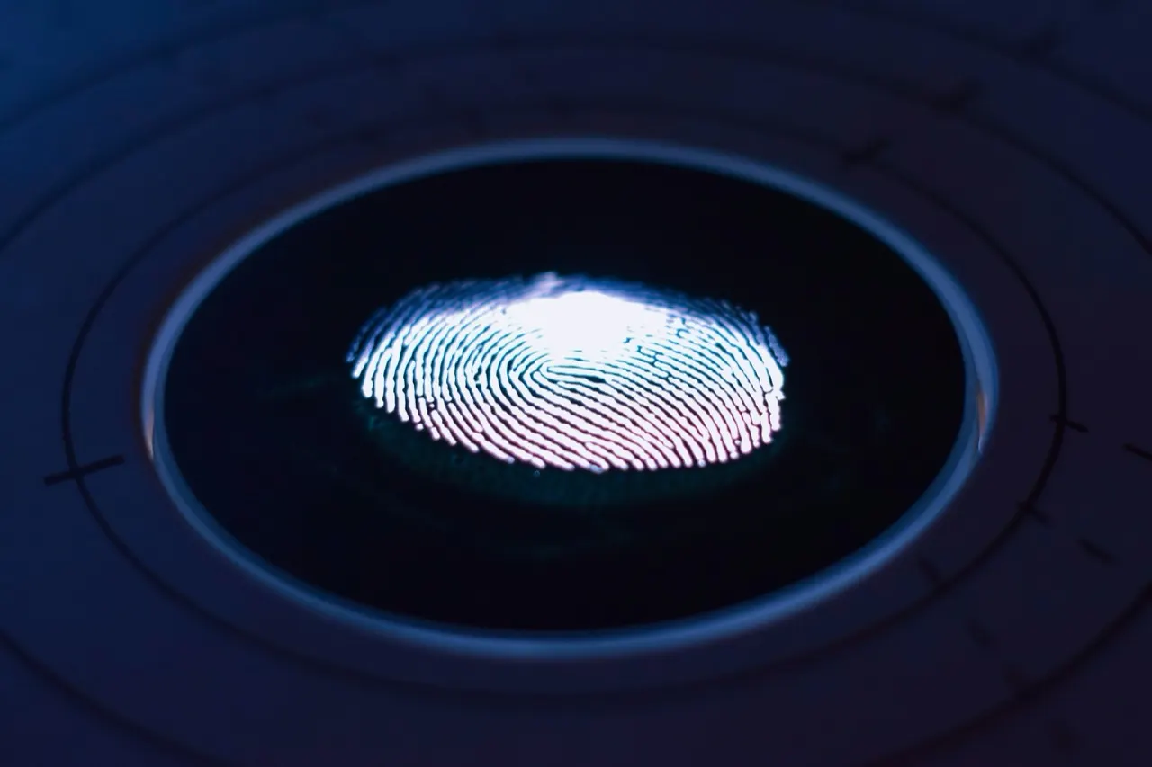 A fingerprint glowing on a biometric scanner